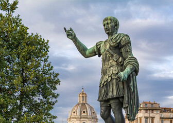 Fototapeta na wymiar Statue of Imp Caesari Nervae with The Church of the Most Holy Name of Mary in background, Rome, Italy