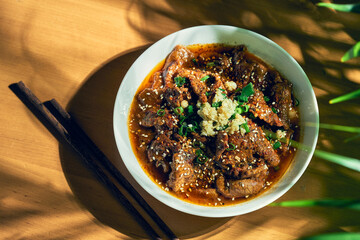 Sichuan spicy beef in a spicy sauce, garlic, pepper, sesame seeds in a white bowl. Chinese cuisine. shuizhu, shui zhu