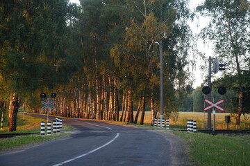 Suburban empty asphalted road turn view to unregulated one way railroad crossing, beautiful Russian...