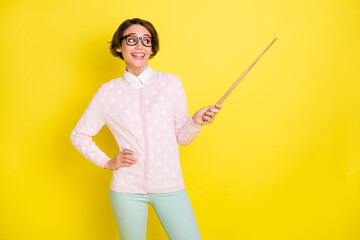 Photo portrait of curious funny girl in glasses pointing at school teaching looking empty space isolated vivid yellow color background