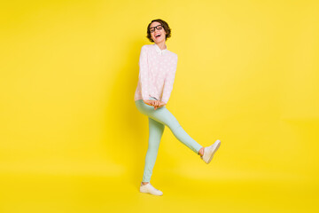 Fototapeta na wymiar Full size photo of funky happy young lady wear casual outfit glasses student isolated on shine yellow color background