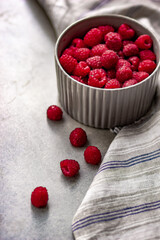 fresh ripe raspberries in a ceramic cup close-up