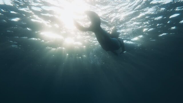 Sirena che nuota in fondo all'oceano