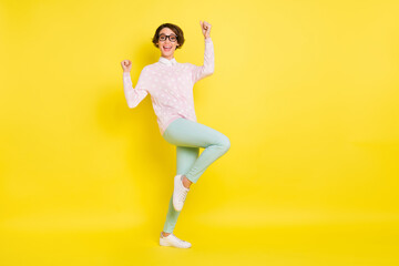Fototapeta na wymiar Full length photo of victorious young brown bob haired woman raise fists lucky win isolated on vivid yellow color background
