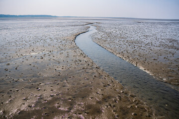 Small river floating through the mudflat of the north sea at sahlenburg, cuxhaven