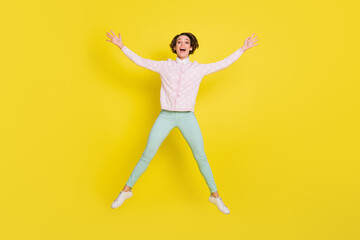 Fototapeta na wymiar Full size photo of cheerful funky young woman jump up air star shape raise hands isolated on bright yellow color background