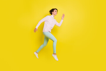 Fototapeta na wymiar Full size profile side photo of happy girl run hurry sale empty space jump air wear green pants isolated on yellow color background