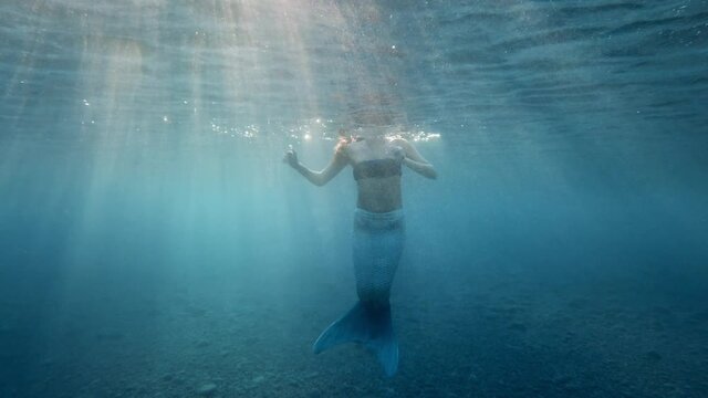 Sirena che nuota in fondo all'oceano