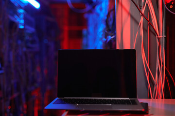Background image of blank laprop screen in dark server room, copy space