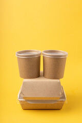Disposable food delivery boxes on yellow background