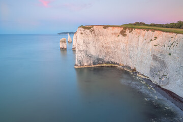 Colourful, idyllic sunset or sunrise sky over seascape landscape of the white chalk cliffs and sea...