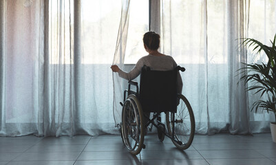 Fototapeta na wymiar Woman in wheelchair at home alone
