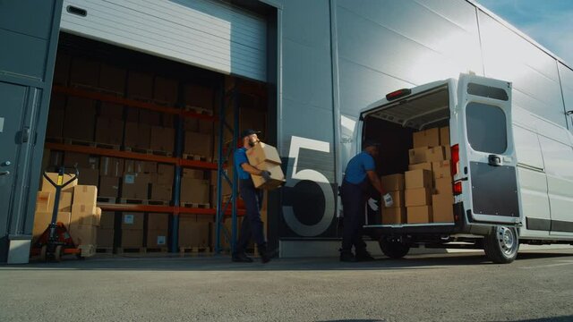 Outside of Logistics Retailer Warehouse with Diverse Team of Workers Loading Delivery Truck with Cardboard Boxes. Delivery of Online Orders, Purchases, E-Commerce Goods. Low Angle Pan Wide Shot