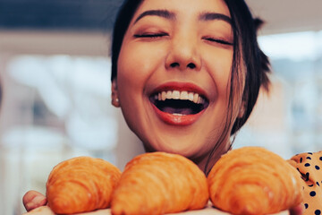 Closeup face Woman happy with fragrance Croissant in shop