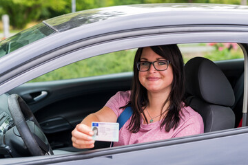Junge Frau zeigt stolz ihren Führerschein