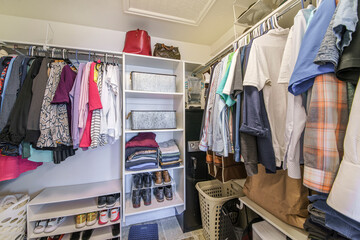 Full small walk in closet with baskets and vault inside
