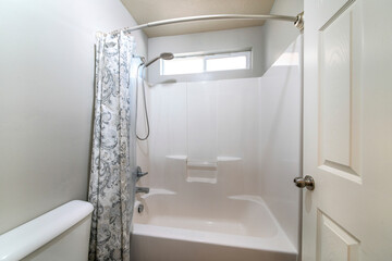Small bathroom with a white door and a tub shower combo set