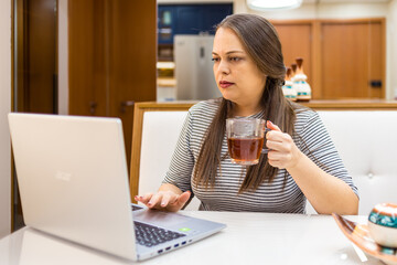 woman with laptop drinking tea