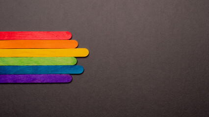 wooden sticks with LGBT rainbow flag on black color background