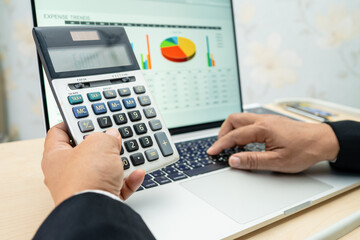 Asian accountant working and analyzing financial reports project accounting with chart graph and...