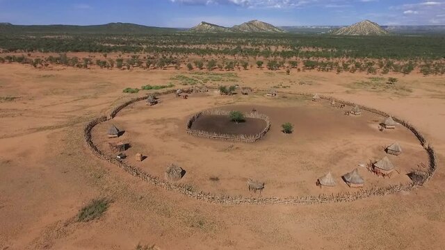 Beautiful aerial footage over a round Himba African tribal settlement and family compound in northern Namibia, Africa. Typical himba village in the bush far away from a city.