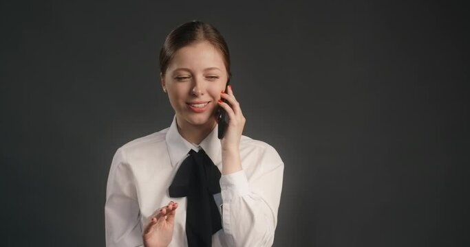 Yong manager woman in business suit has a business talk with client via mobile phone, work with objections, sells by the phone, 4k 120fps Prores HQ