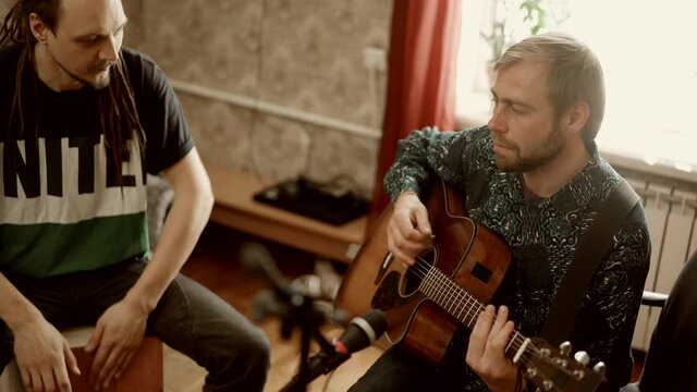 Male musicians rehearsing together at home
