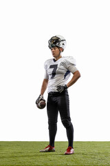 Portrait of young American football player, athlete in sports equipment standing isolated on white studio background. Concept of professional sport, championship, competition.
