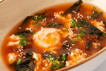 Asian noodle soup in bowl on gray background