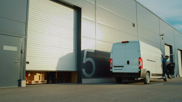 Outside of Logistics Distributions Warehouse  Delivery Truck Stops: Manager Using Tablet Computer, Workers Start Unloading Cardboard Boxes. Online Orders, Purchases, E-Commerce Goods. Wide Shot