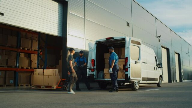 Outside of Logistics Distributions Warehouse With Manager Using Tablet Computer, Workers Start Loading Delivery Truck with Cardboard Boxes. Online Orders, Purchases, E-Commerce Goods. Wide Shot