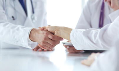 Obraz premium Doctor shaking hands with a male patient in the office