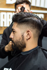 Fototapeta premium Man getting a haircut in a barbershop