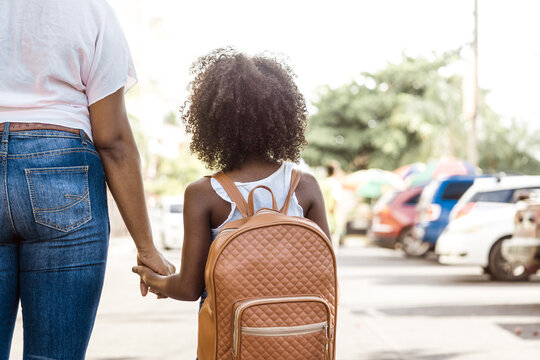 little girl with backpack holds a person's hand. back to school concept.
