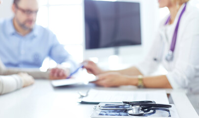 Obraz premium Doctor in clinic asking senior woman in wheelchair for a signature
