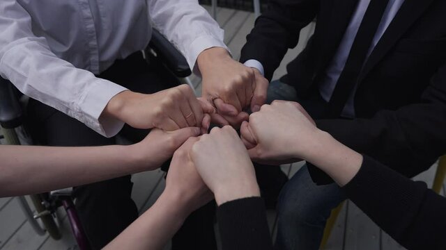 Hands of unrecognizable business team putting fists together. Confident Caucasian men and women brainstorming planning project. Partnership and teamwork concept
