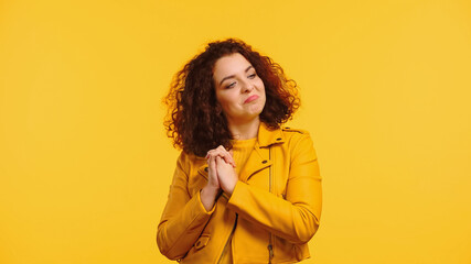 proud young woman with clenched hands looking away isolated on yellow