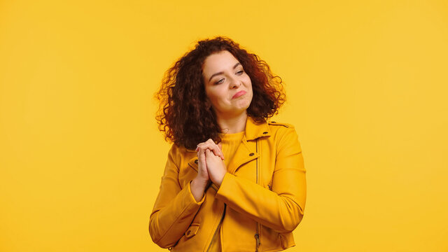 Proud Young Woman With Clenched Hands Looking Away Isolated On Yellow