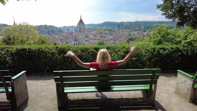 Tourist girl by the panorama of Schaffhausen Swiss historic town in Switzerland. Lookout of terraced vineyards with cityscape aerial view on the river Rhine. Swiss capital of canton Schaffhausen.