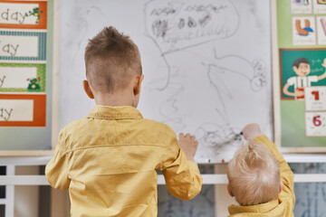 Brothers drawing on a board