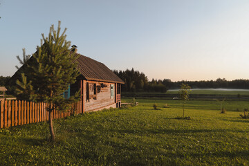 wooden european house in a picturesque countryside at sunset in summer