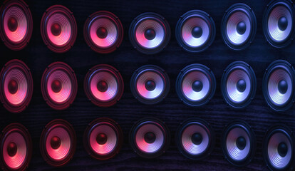 Group of sound speakers in neon light on black.