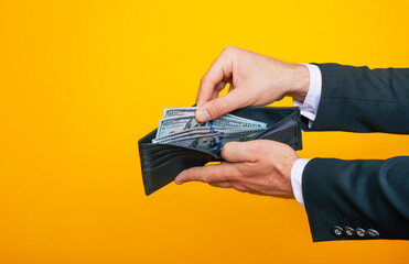 Close up photo of young successful businessman hands with wallet and bunch of dollars of USA