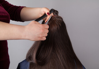 Fototapeta premium Professional Hairdresser female cutting caucasian woman's hair.