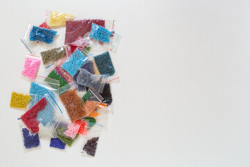 Colored packed beads pile with space for text on the right. Creative flat lay with copy space for beading handcrafters