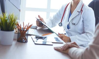 A doctor is talking and examining a patient