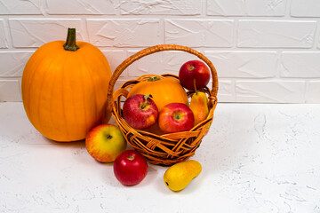 Close up autumn harvest background. Still life with ripe pumpkin, apples, pears and autumn leaves on a white background.