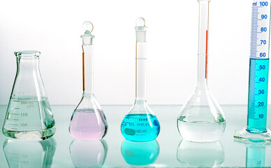 Set of laboratory glassware (beaker) filled different color liquid with reflection on a white background. Drug development concept.	