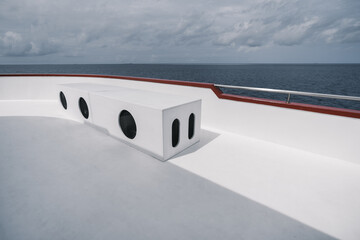 View from the upper deck of a safari boat with a rectangular box bench with three round holes from...