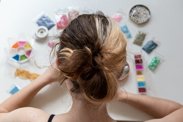 Young girl with colorful split hair in the process of deading handcraft. Calming stress releasing...